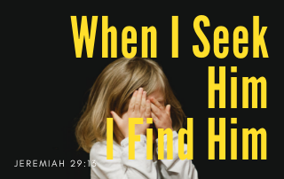 A young girl with her hands over her eyes. The words "When I Seek Him, I Find Him" in yellow