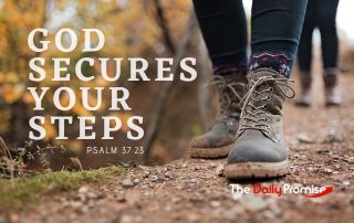 Close up a walking boots along a narrow path. the lettering reads "God Secures Your Steps.