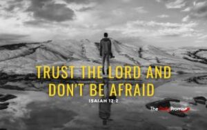 A man is facing a mountain in a black and white photo. The caption reads "Trust the Lord and Don't be Afraid."