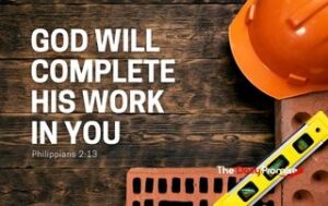 Several construction related items like a hard hat, bricks and a level laying on a dark wood background. "God Will Complete His Work in You"