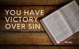 A Bible opened on brown wood slates. "You Have Victory Over Sin"