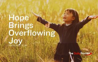 A small girl with hands raised in praise is standing in a wheat field. "Hope Brings Overflowing Joy"