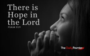 A woman praying with her eyes lifted, on ablack background - There is Hope in the Lord - Psalm 31:24