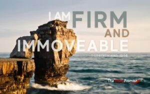 A large rock is sticking out of the ocean, with the waves crashing against it. "I am Firm and Immovable." 1 Corinthians 15:58