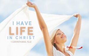 A woman with hands raised holding a white sheet in the wind - "I Find Life in Christ" - 1 Corinthians 15:22