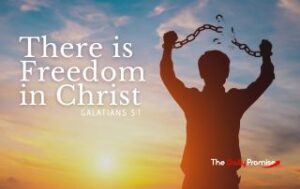 A man stands with his arms raised, breaking a chain. "There is Freedom in Christ"