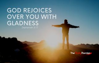 A mans standing on a hill with the sun shining on him. "God Rejoices Over You With Gladness"