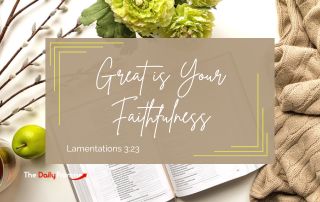 An open bible with a brown sweater and flowers lay beside it. The words - "Great is Your Faithfulness."