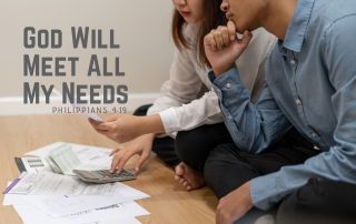 A couple sitting on the floor reviewing their bills - "God Will Meet All My Needs." Philippians 4:19