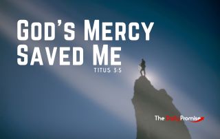 A man standing on a mountain point with a beam of light focused on him. "God's Mercy Saved Me" - Titus 3:5