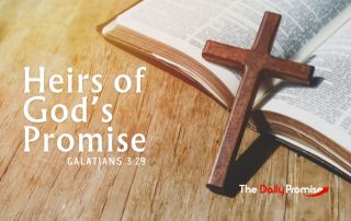 An open Bible with a small wood cross laying aginst it. The caption reads, "Heirs of God's Promise" Galatians 3:29