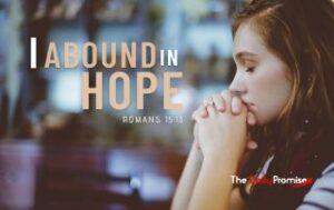 A woman praying with folded hands. "I Abound in Hope" - Romans 15:13