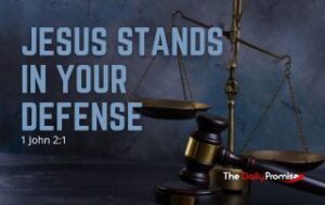 Scales of justice with an anvil on a blue background. "Jesus Stands in Your Defense" - 1 John 2:1