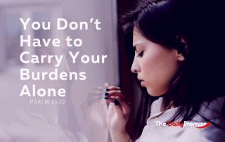 A woman is looking out a window with a worried look on her face. Beside her are the words, “You Don't Have to Carry Your Burdens Alone” – Psalm 55:22