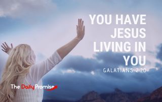 A woman is facing clouds with hands raised against a cloudy sky. The words "You Have Jesus Living in You" are in large white letters. - Galatians 2:20