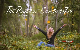 A woman is sitting in the woods with her hands raised in joy. "The Power of Joy" - Philippians 4:4